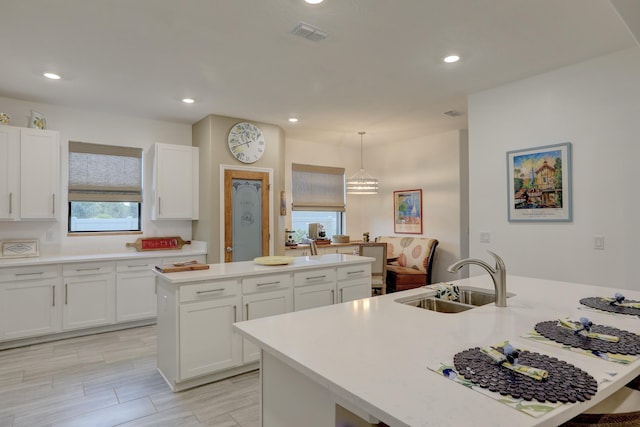 5561 1st Sq SW, Vero Beach, FL 32968 - kitchen featuring a sink, visible vents, light countertops, and an island with sink