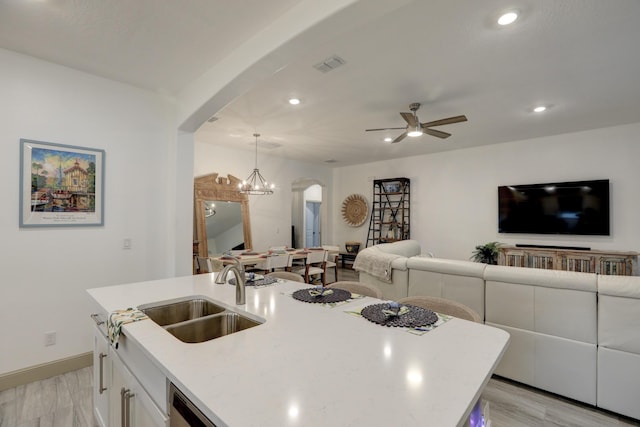 5561 1st Sq SW, Vero Beach, FL 32968 - kitchen with visible vents, arched walkways, white cabinetry, a sink, and open floor plan