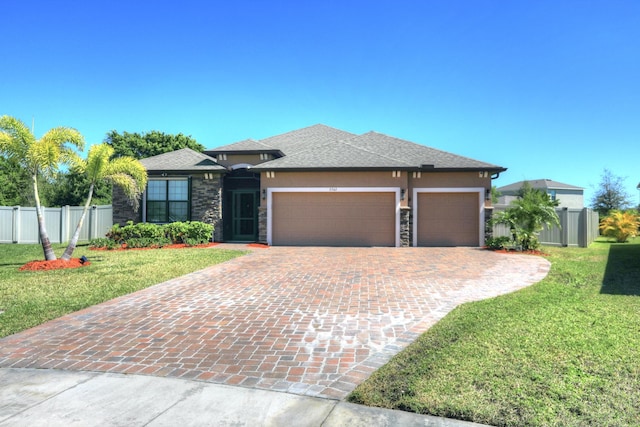 5561 1st Sq SW, Vero Beach, FL 32968 - prairie-style home with stucco siding, fence, a front lawn, decorative driveway, and a garage