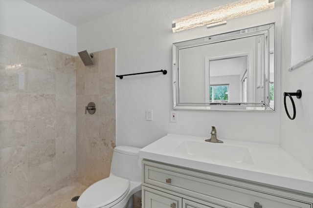 full bathroom featuring toilet, vanity, and a tile shower