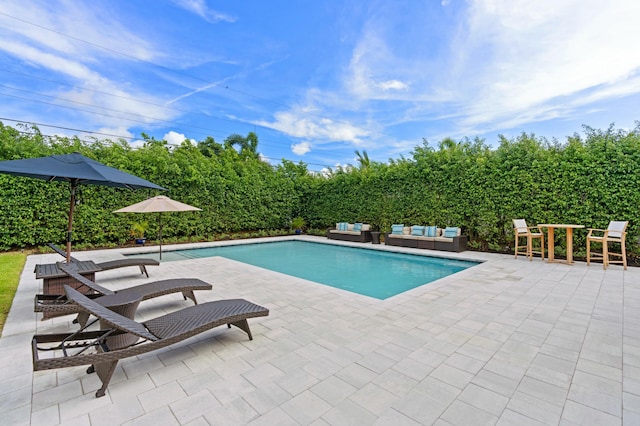 view of swimming pool featuring an outdoor living space, a fenced in pool, and a patio area