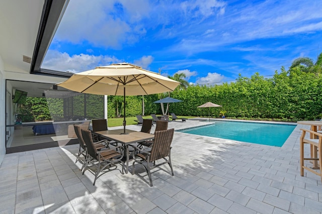 outdoor pool with a patio area and outdoor dining space