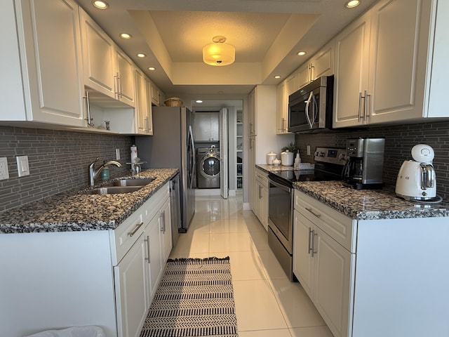 2003 N Ocean Blvd Unit 305N, Boca Raton, FL 33431 - kitchen with washer / dryer, light tile patterned flooring, a sink, appliances with stainless steel finishes, and a raised ceiling