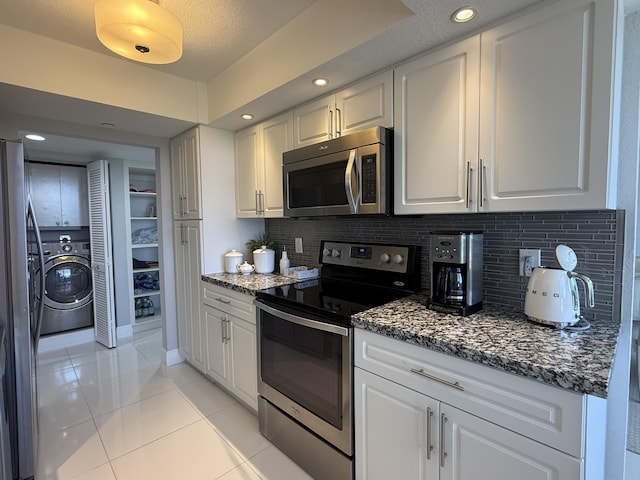 2003 N Ocean Blvd Unit 305N, Boca Raton, FL 33431 - kitchen featuring light tile patterned floors, washer / dryer, white cabinetry, and stainless steel appliances