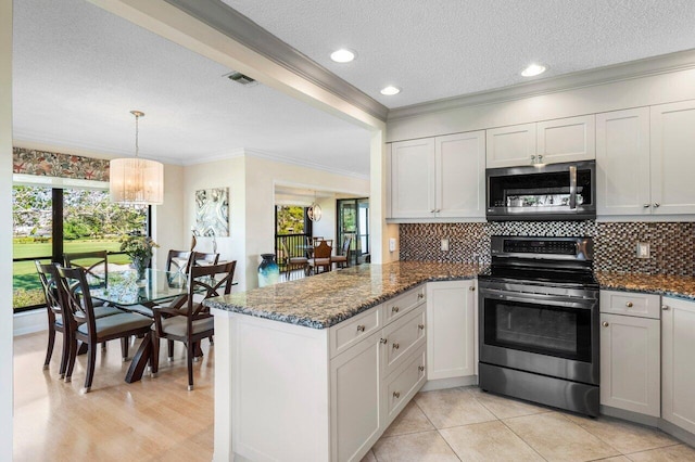 kitchen with a wealth of natural light, visible vents, ornamental molding, stainless steel appliances, and a peninsula