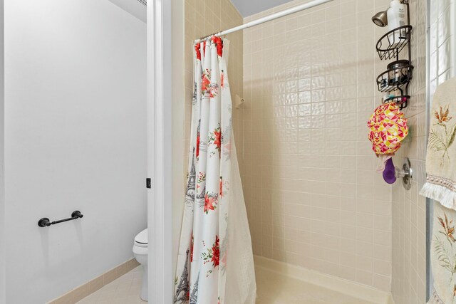 3251 Perimeter Dr, Greenacres, FL 33467 - full bathroom featuring a tile shower, tile patterned floors, toilet, and baseboards