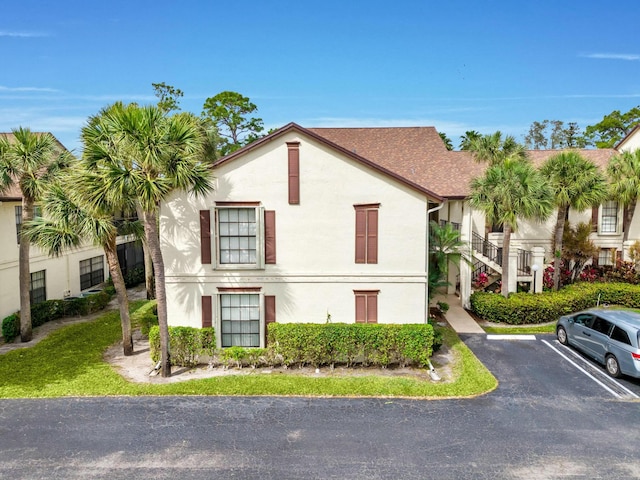 3251 Perimeter Dr, Greenacres, FL 33467 - view of property exterior featuring stucco siding, uncovered parking, and stairs