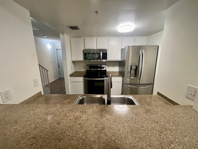 kitchen with a sink, visible vents, white cabinets, and appliances with stainless steel finishes
