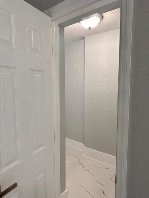 interior space featuring baseboards and marble finish floor