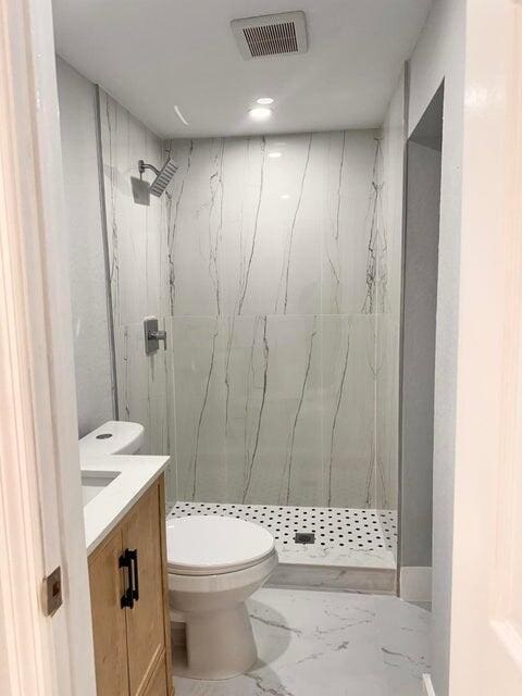 full bathroom with vanity, visible vents, a marble finish shower, toilet, and marble finish floor