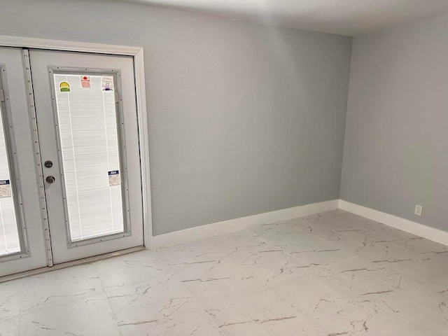 spare room with baseboards and marble finish floor