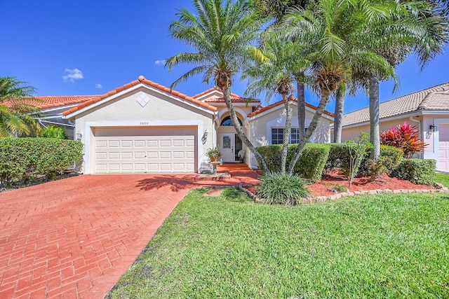 22822 Sterling Lakes Dr, Boca Raton, FL 33433 - mediterranean / spanish house featuring a tile roof, a front yard, stucco siding, decorative driveway, and a garage