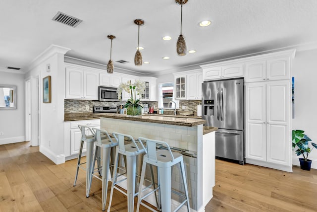 kitchen with visible vents, a center island, light wood-type flooring, and appliances with stainless steel finishes