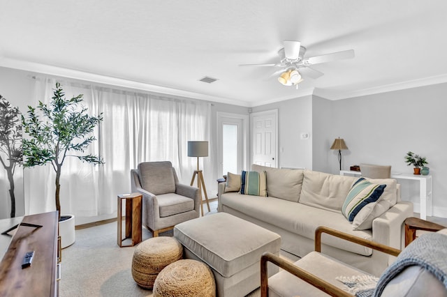 living room featuring visible vents, ornamental molding, and a ceiling fan