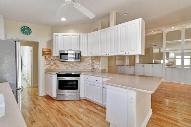 kitchen with stainless steel appliances, a ceiling fan, a peninsula, light wood-type flooring, and recessed lighting