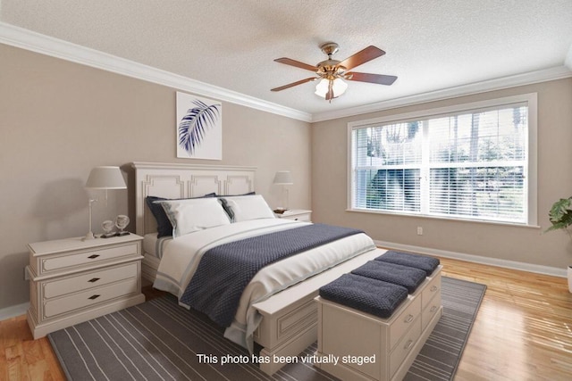 bedroom with light wood finished floors, crown molding, baseboards, a textured ceiling, and a ceiling fan