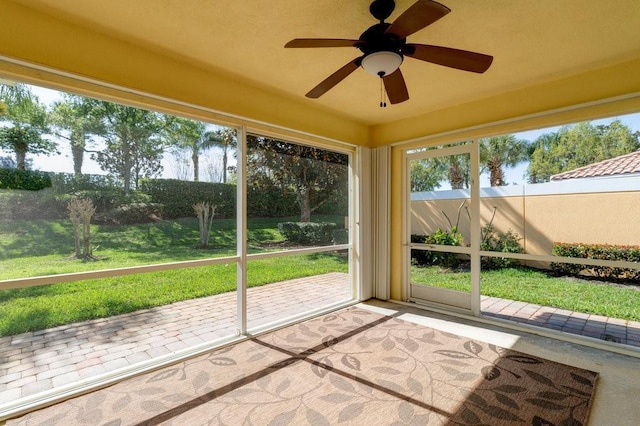 unfurnished sunroom featuring a ceiling fan
