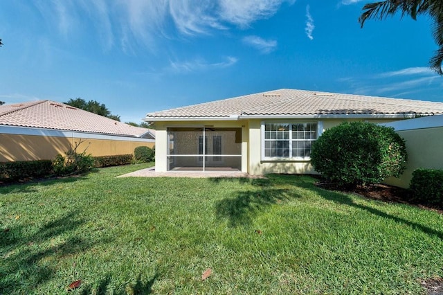 rear view of property with stucco siding, a sunroom, and a tile roof