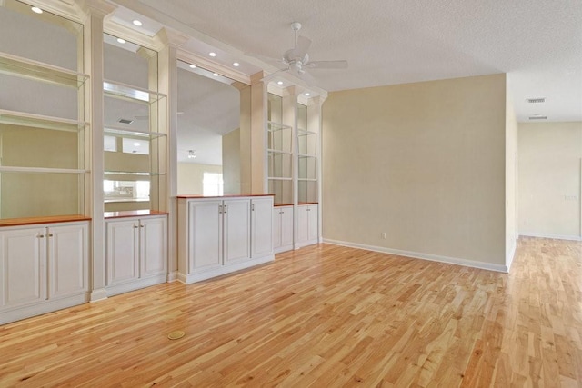 spare room with a ceiling fan, light wood finished floors, baseboards, recessed lighting, and a textured ceiling