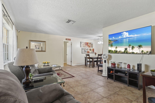 7003 Arthurs Rd, Fort Pierce, FL 34951 - living room with a ceiling fan, baseboards, visible vents, light tile patterned flooring, and a textured ceiling