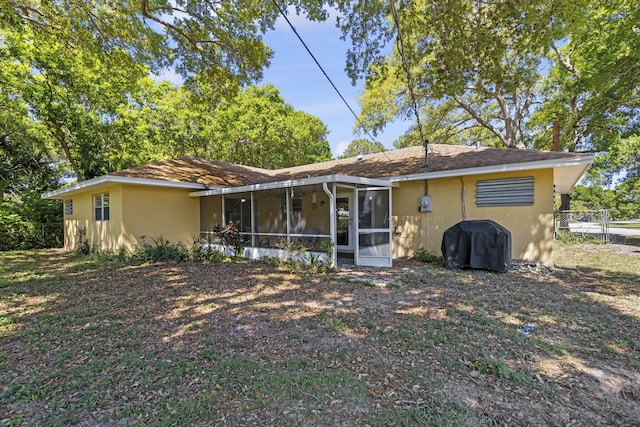 7003 Arthurs Rd, Fort Pierce, FL 34951 - rear view of property featuring roof with shingles, fence, a sunroom, and stucco siding