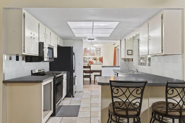 7003 Arthurs Rd, Fort Pierce, FL 34951 - kitchen featuring a peninsula, electric range, and dark countertops