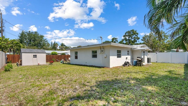 4142 NE Robin Ct, Jensen Beach, FL 34957 - back of property with stucco siding, a fenced backyard, and a storage unit