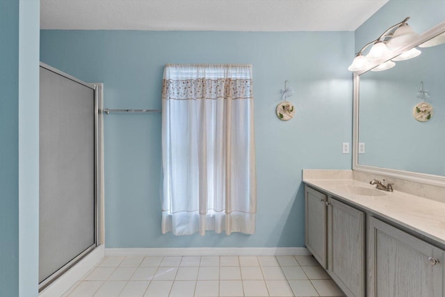 bathroom featuring vanity, baseboards, a wealth of natural light, and a textured ceiling