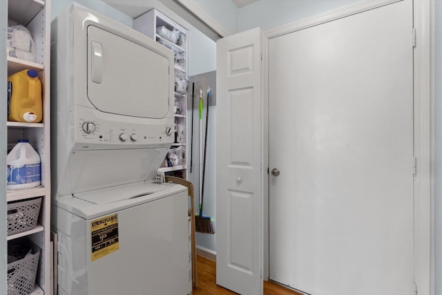 laundry room with laundry area, light wood-style floors, and stacked washer and clothes dryer