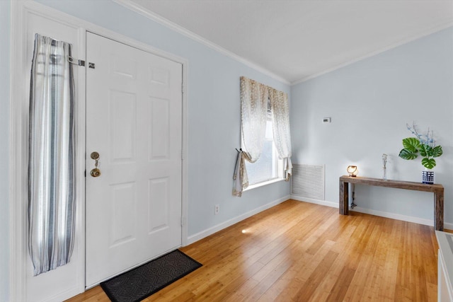 foyer with visible vents, baseboards, light wood-style flooring, and crown molding