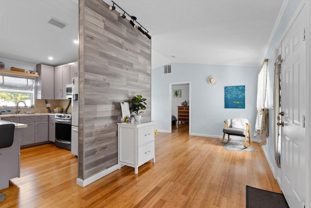 kitchen with visible vents, gray cabinetry, stainless steel electric range, light wood-style floors, and a sink