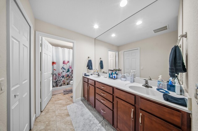 full bathroom featuring tile patterned floors, visible vents, toilet, a sink, and double vanity