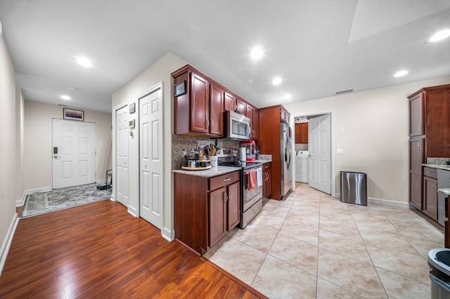 kitchen with stainless steel appliances, light stone countertops, backsplash, and visible vents