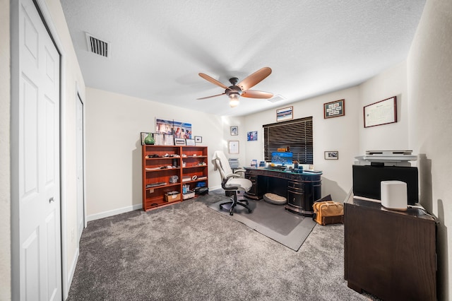 carpeted office featuring baseboards, a ceiling fan, visible vents, and a textured ceiling