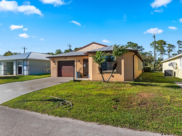 ranch-style home featuring a front lawn, metal roof, driveway, an attached garage, and a standing seam roof