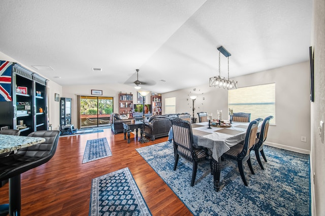 dining area with visible vents, ceiling fan, vaulted ceiling, wood finished floors, and a textured ceiling