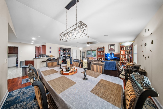 dining room featuring wood finished floors, visible vents, washer / dryer, lofted ceiling, and ceiling fan