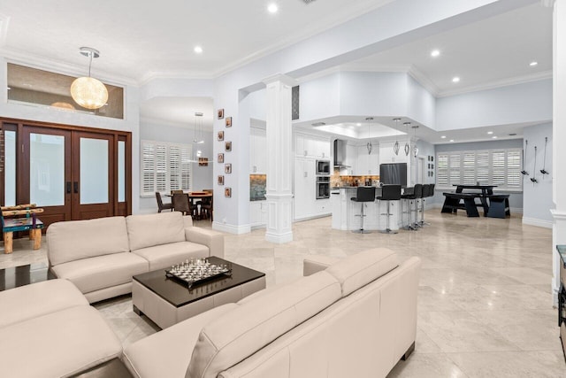 living area with crown molding, french doors, baseboards, and ornate columns