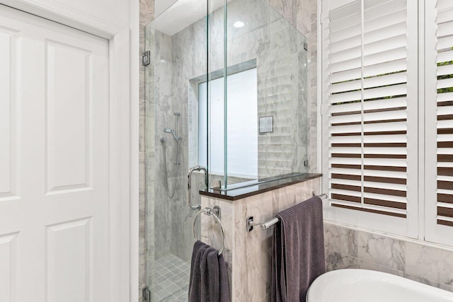 full bath featuring a soaking tub and a stall shower