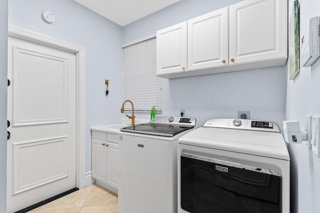 washroom featuring a sink, cabinet space, independent washer and dryer, and light tile patterned floors