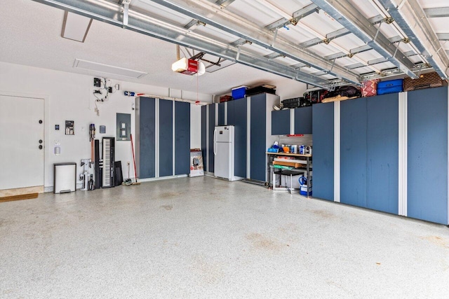 garage featuring electric panel, a garage door opener, and freestanding refrigerator