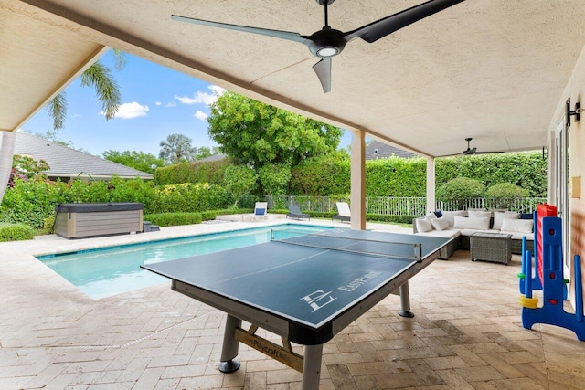 exterior space with a fenced backyard, an outdoor pool, an outdoor hangout area, ceiling fan, and a hot tub
