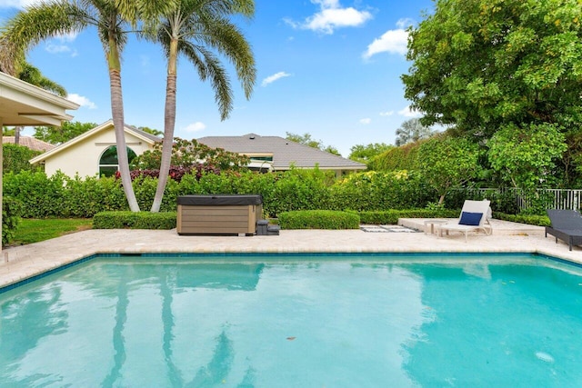 view of swimming pool with a fenced in pool, a patio, fence, and a hot tub