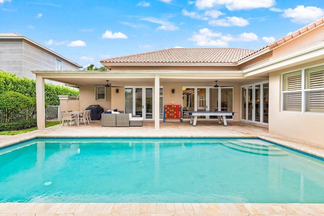 view of pool with an outdoor living space, french doors, a patio, and fence