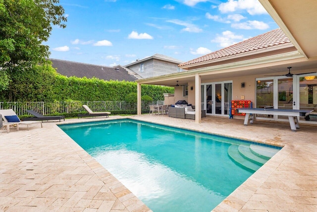 view of swimming pool with a patio, fence, ceiling fan, french doors, and an outdoor hangout area