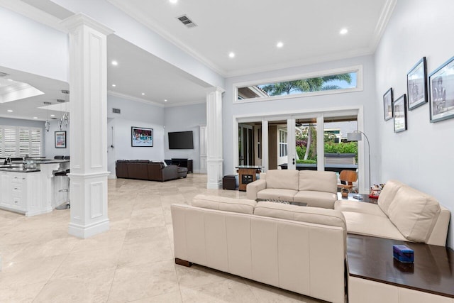 living area with crown molding, recessed lighting, visible vents, and ornate columns
