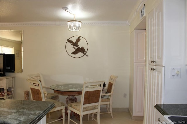 dining area featuring light tile patterned floors, visible vents, crown molding, and baseboards