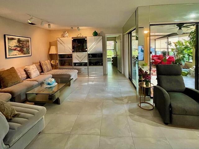 living area featuring track lighting, a healthy amount of sunlight, and ceiling fan