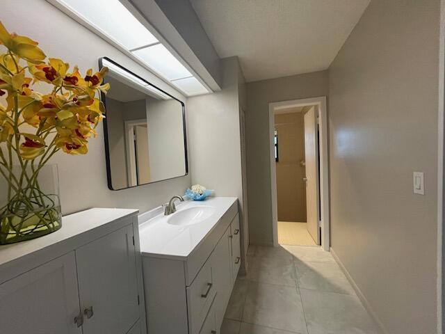 bathroom with baseboards, vanity, and tile patterned flooring