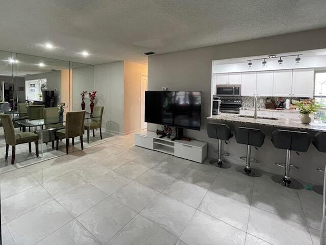 living room featuring a textured ceiling, recessed lighting, and light tile patterned floors